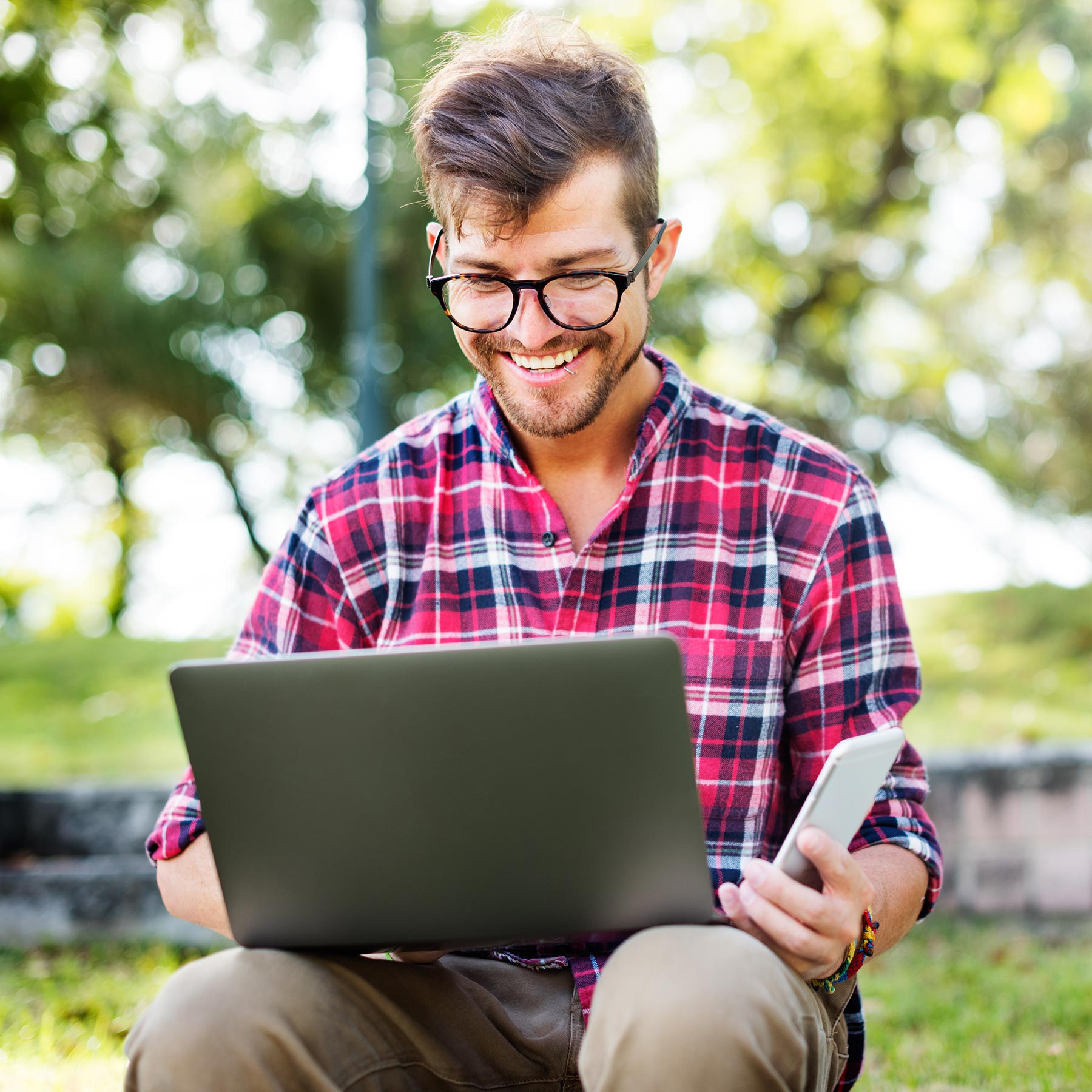 young-man-smartphone-browsing-laptop-concept-PL96PN7.jpg